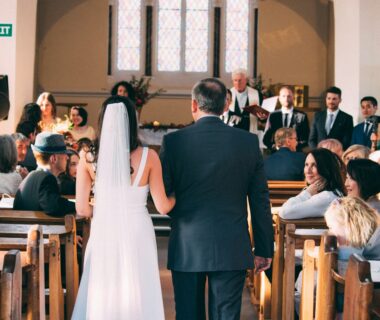 bride walking together with man inside church surrounded with people