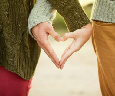 person forming heart shape with their hands