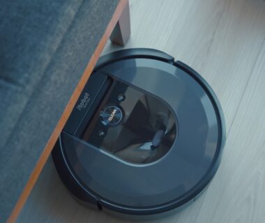 a robotic vacuum is on the floor next to a couch